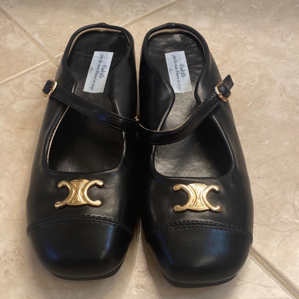 Black Mary Jane style mules with gold hardware.